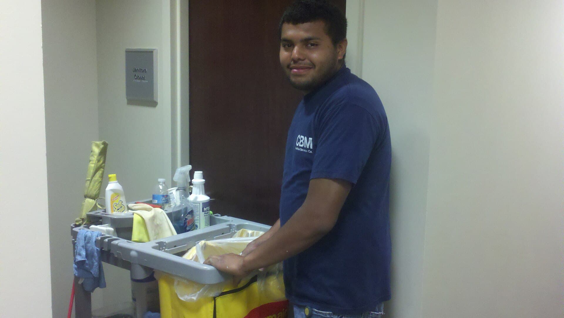 Cleaner working with a mop in a commercial interior